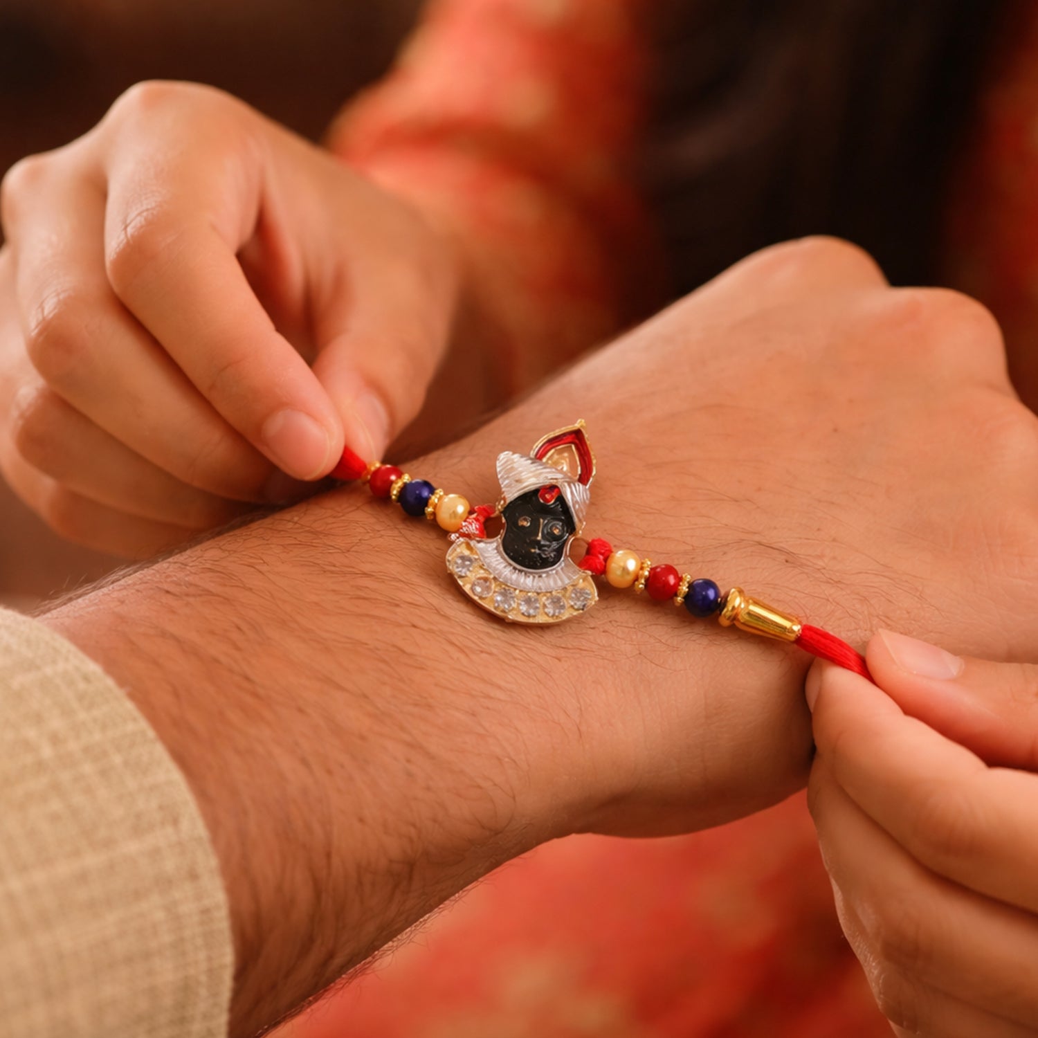 Decorative festive Krishna Rakhi on soft thread