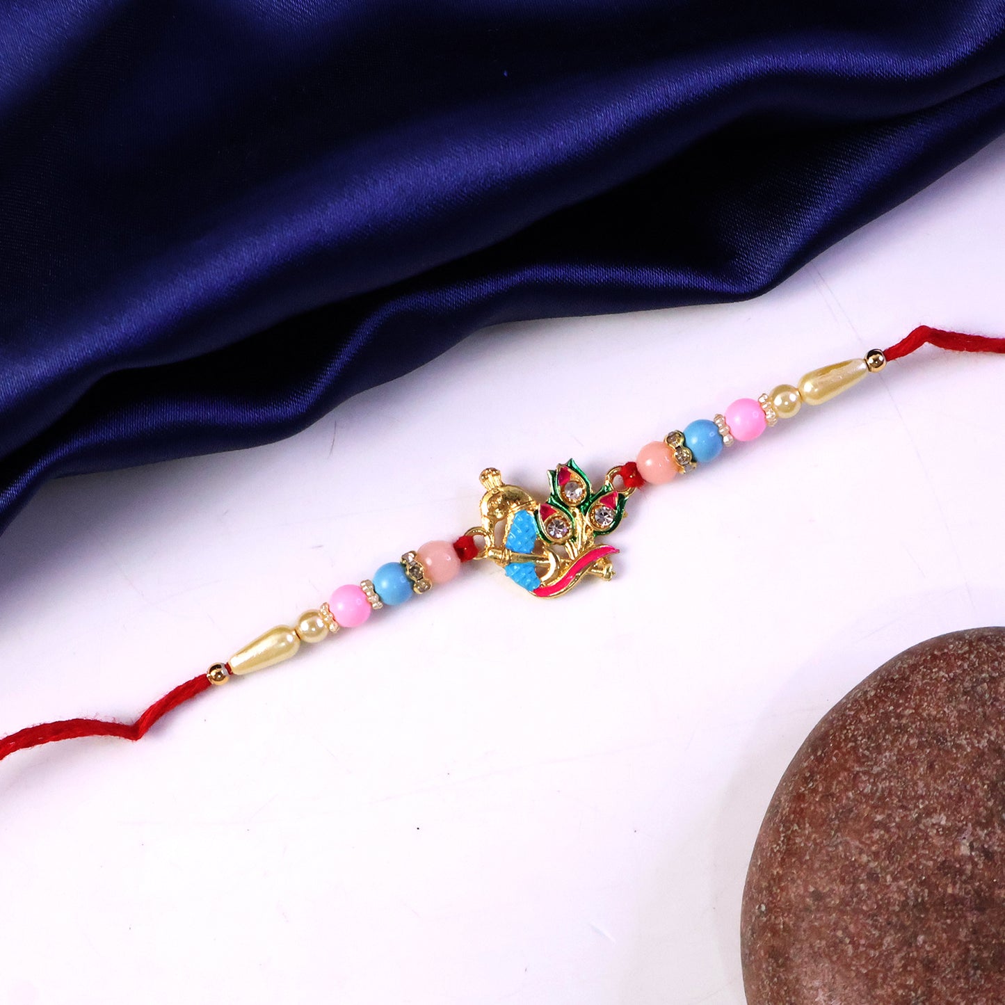 Festive rakhi featuring peacock design and colorful beads