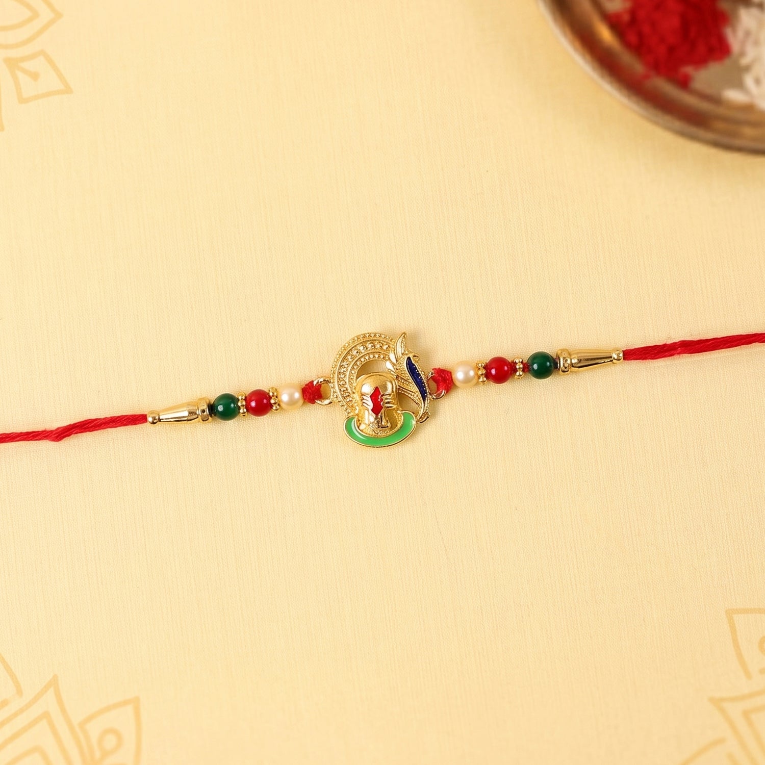 Top view of Ganesha rakhi highlighting thread and beads