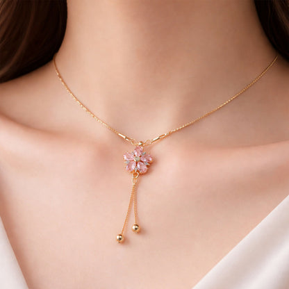 Close-up of pink floral crystal pendant with sparkling centerpiece and gold chain