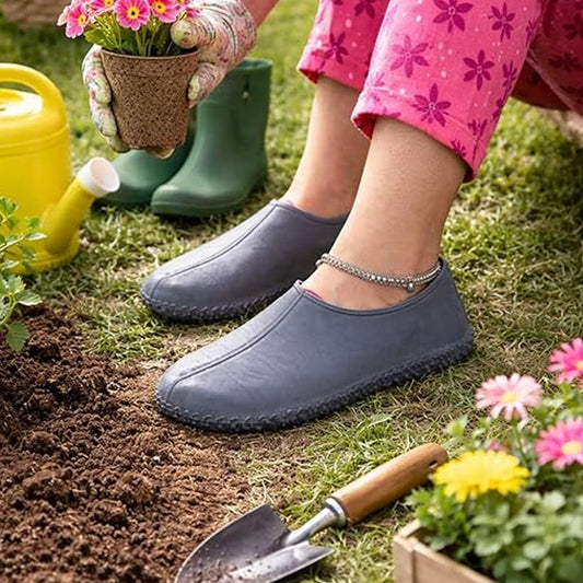 A person gardening wears grey silicone shoe covers over their shoes, with an anklet visible on one ankle.