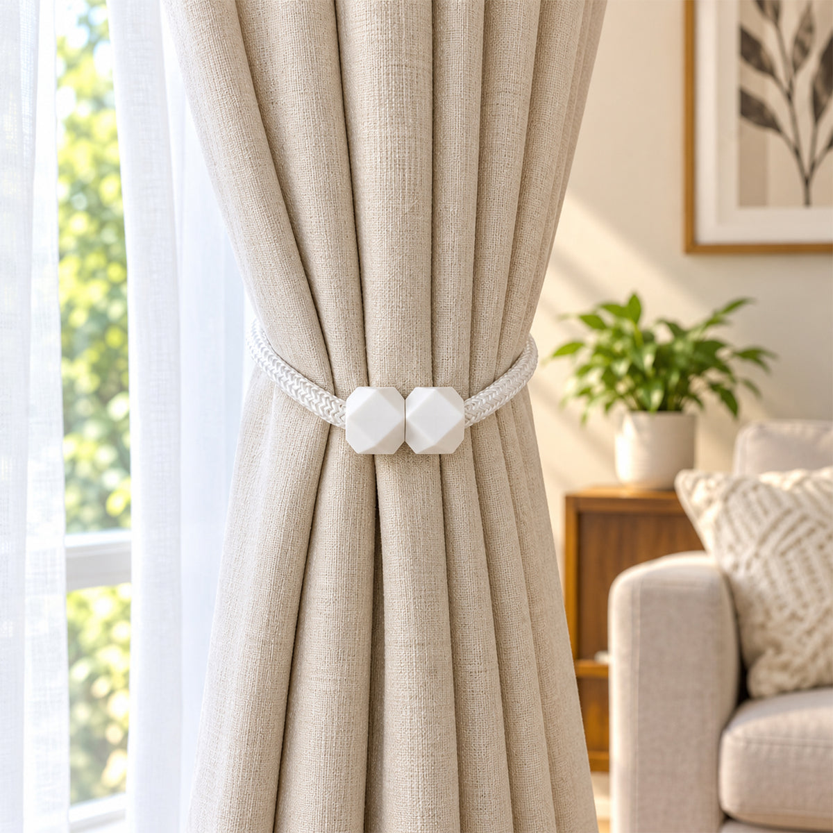 A beige curtain held back by a white braided rope tieback with geometric white plastic fasteners, in a bright room.