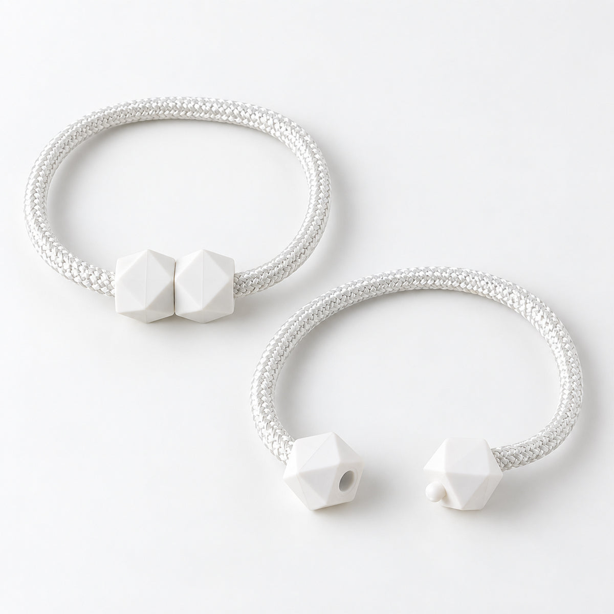 Two white braided rope curtain tiebacks with geometric white plastic fasteners on a plain white background.