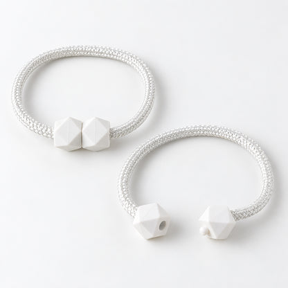 Two white braided rope curtain tiebacks with geometric white plastic fasteners on a plain white background.
