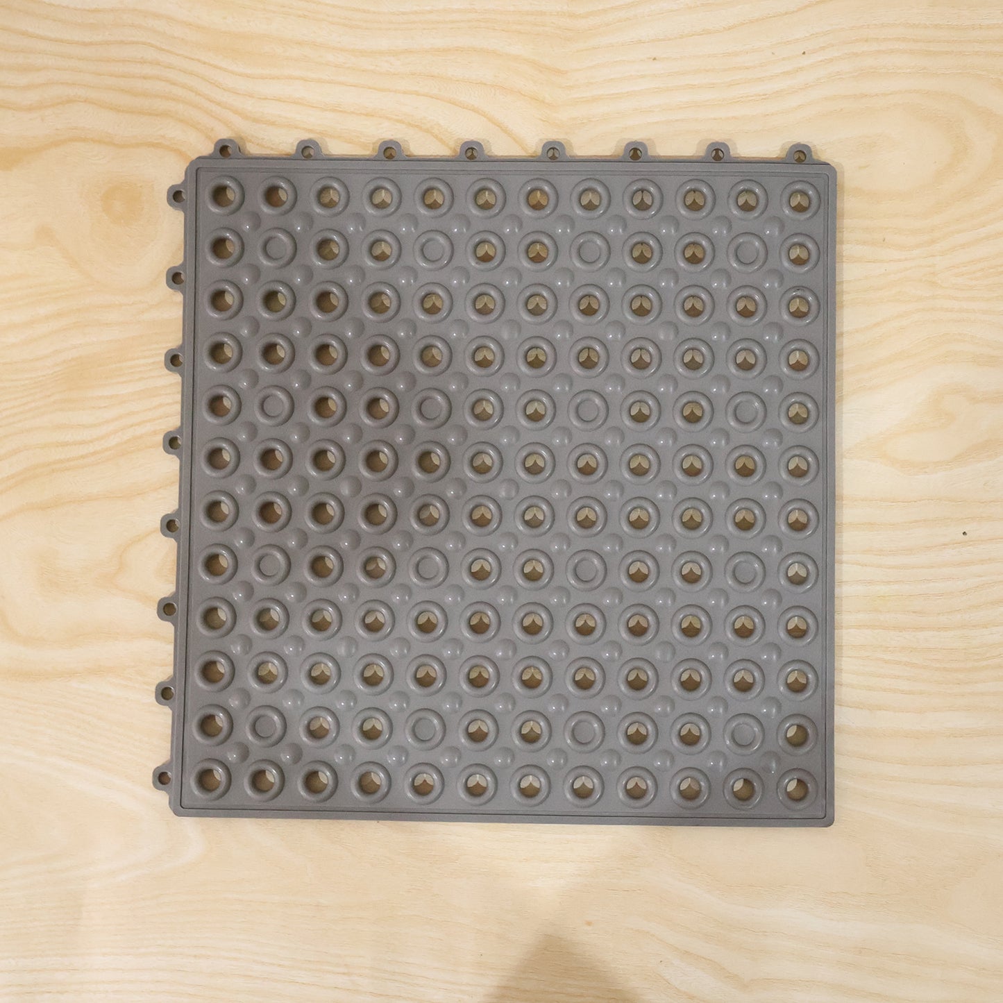 Close-up of textured surface and drainage holes in bathroom anti slip mat