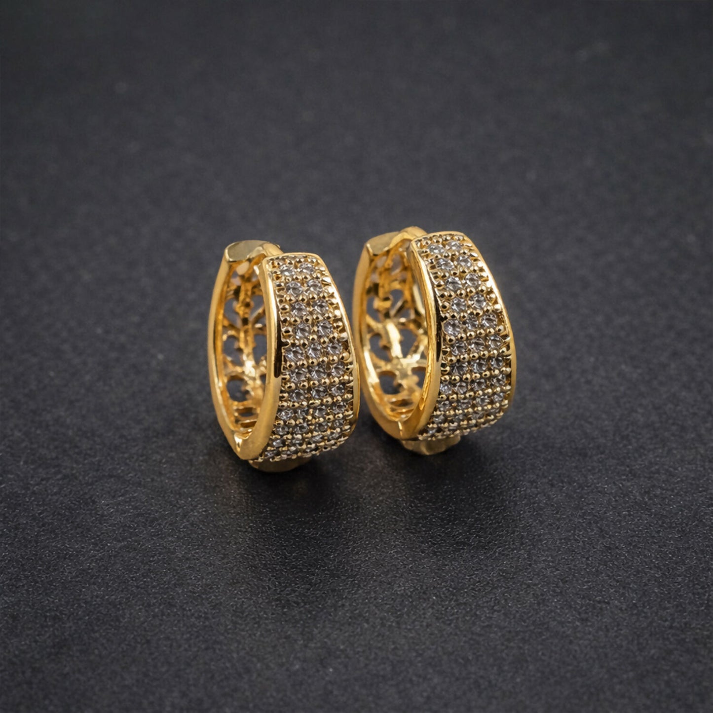 Close-up of gold hoop earrings displaying intricate open lattice pattern inside