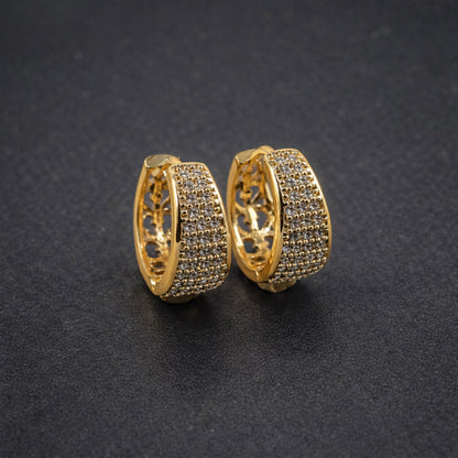 Close-up of gold hoop earrings displaying intricate open lattice pattern inside