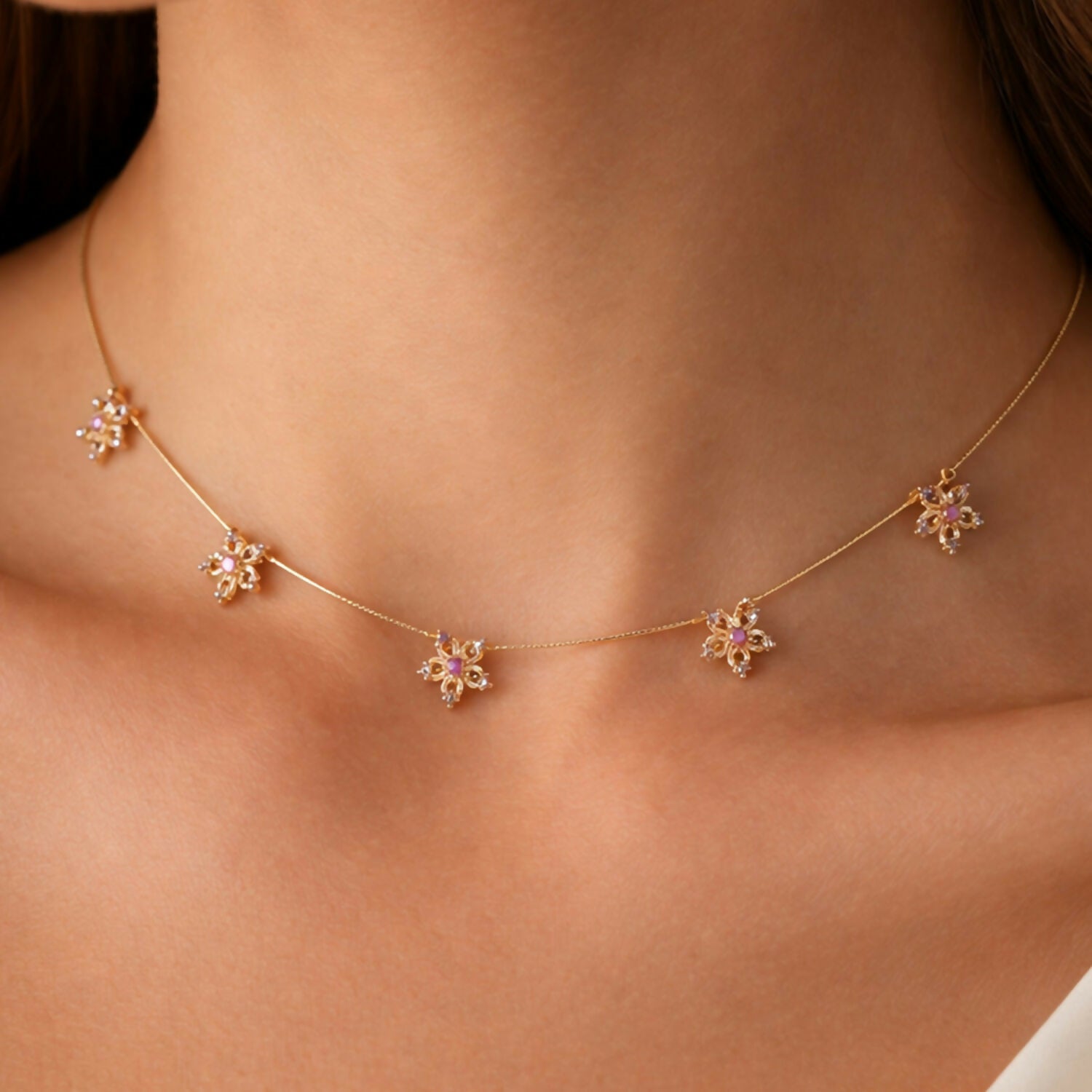 Close-up of floral star design on gold chain necklace