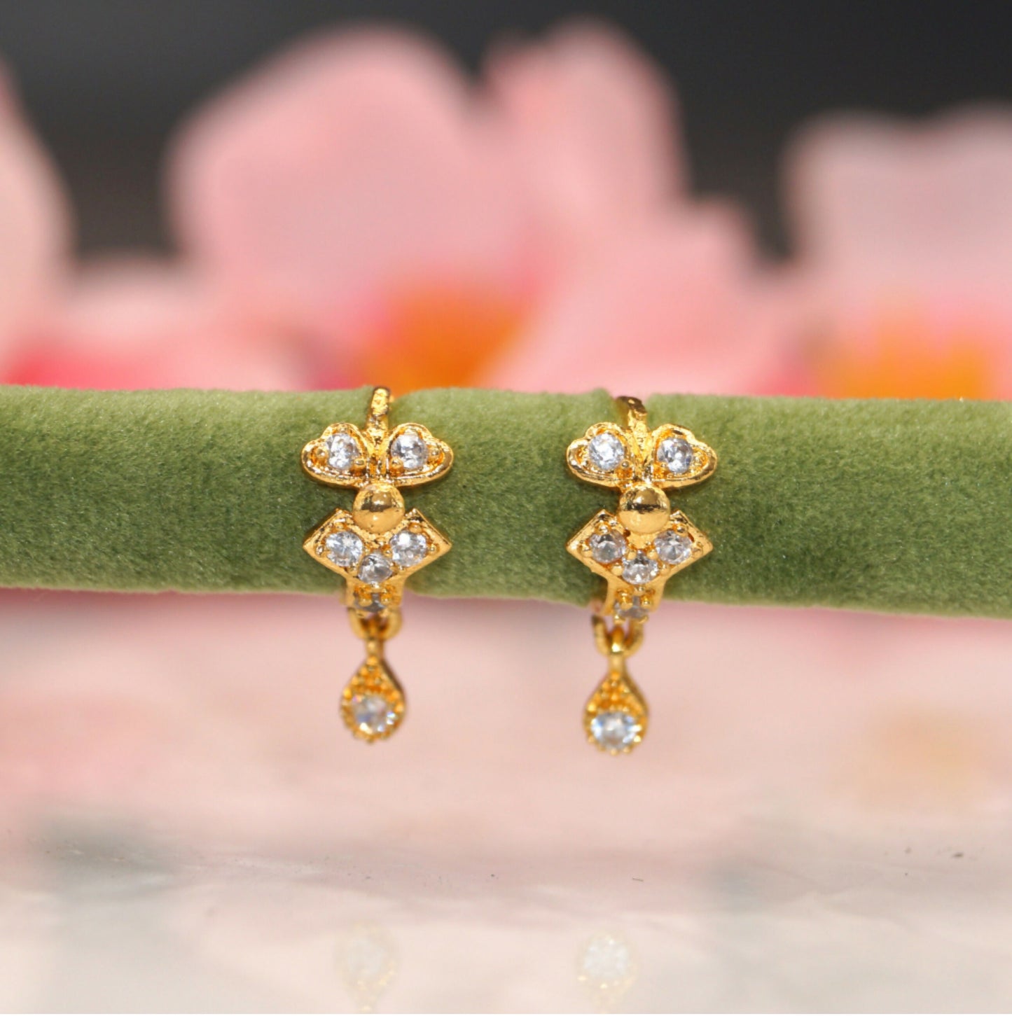 Gold plated peacock and swan dangle huggie hoop earrings featuring sparkling CZ stones