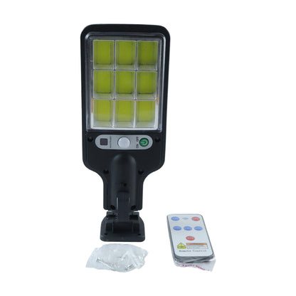 The black solar LED street light, remote control, and mounting screws are arranged on a white background.