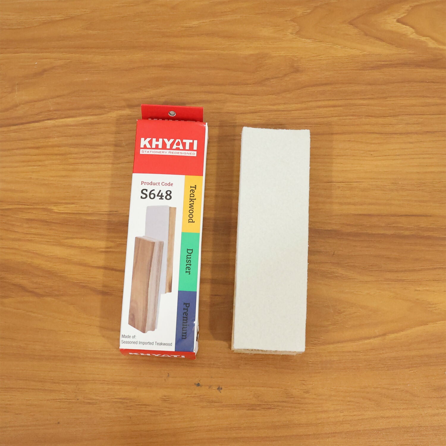 Wooden whiteboard duster next to office supplies