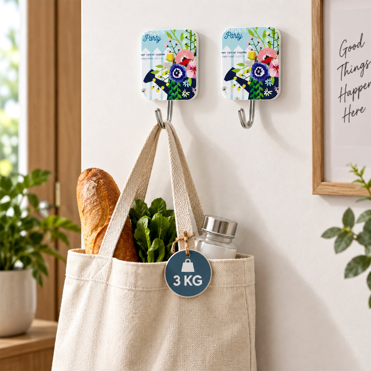 Two decorative adhesive hooks on a wall, one holding a canvas tote bag filled with groceries, indicating 3kg capacity.