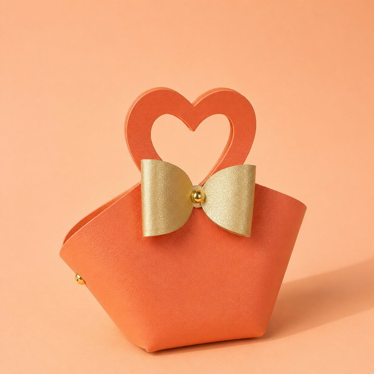 Stylish orange mini handbag showing bow design