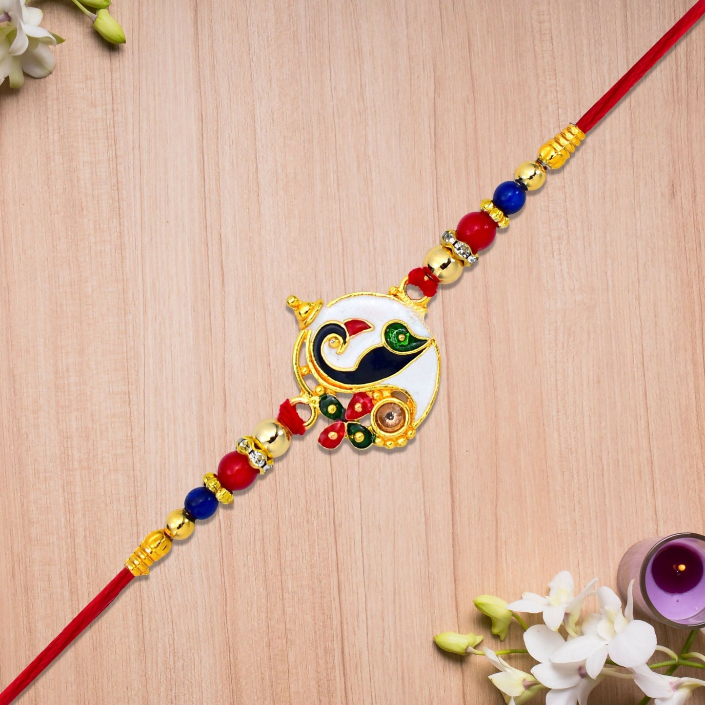 Close-up of Ganesha Rakhi featuring intricate peacock enamel charm and colorful beads