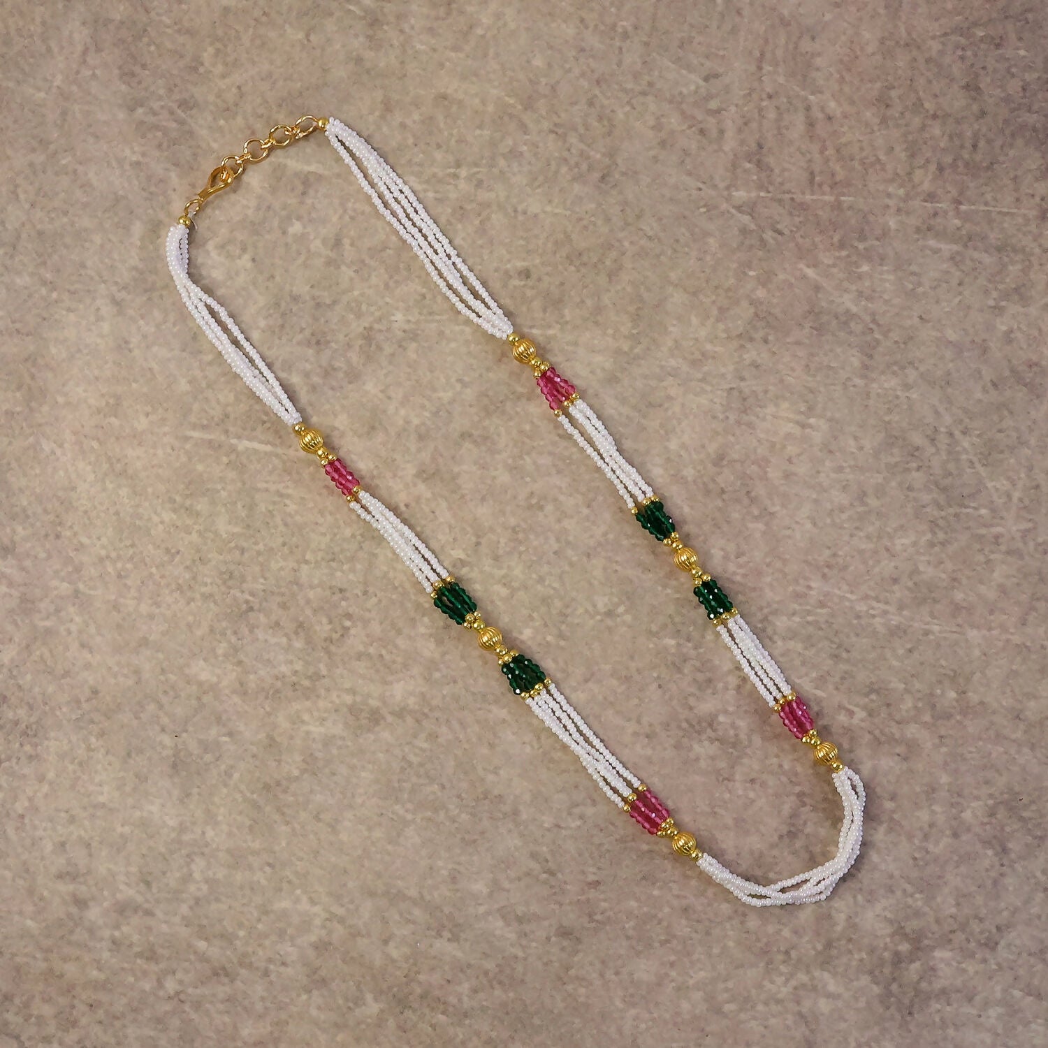 Traditional mala necklace displayed on white background showing bead colors and layers