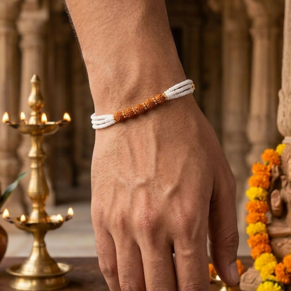 Close-up of triple-strand white pearl-finish beads with gold-toned spacers