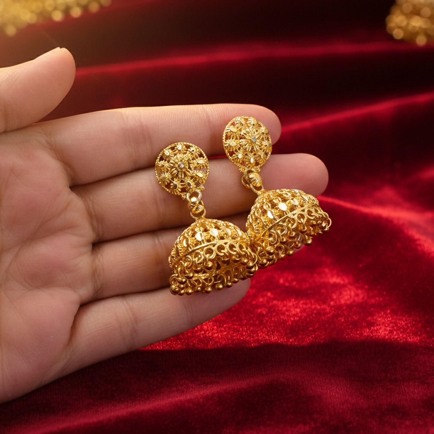 Side view of gold plated jhumka earrings showing intricate pattern and bead hangings