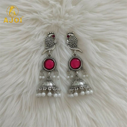 Detailed carved peacock design on silver jhumka earrings