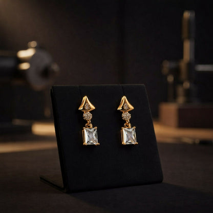 Side angle view of elegant gold tone crystal drop earrings with sparkling stones