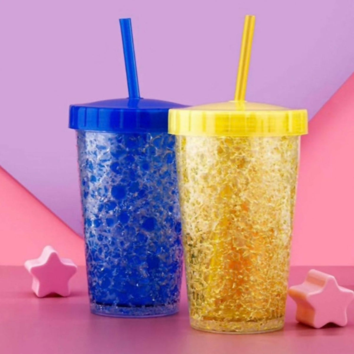 Two colorful plastic tumblers, one blue and one yellow, with straws on a purple and pink background.