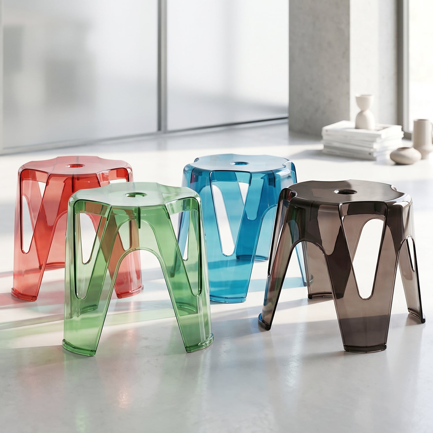 A collection of transparent plastic stools in various subtle colours.