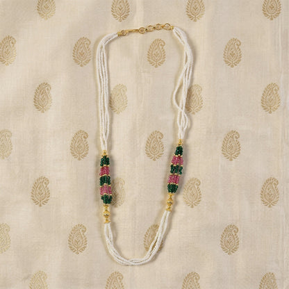 Close-up of green and pink bead details on white mala necklace