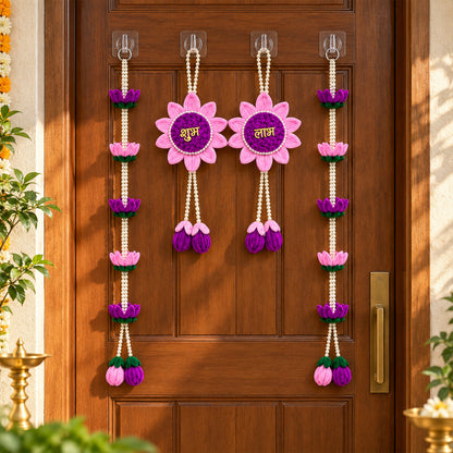 A pair of pink and purple lotus flower hangings and two lotus bead strings on a brown door, with a brass lamp visible.