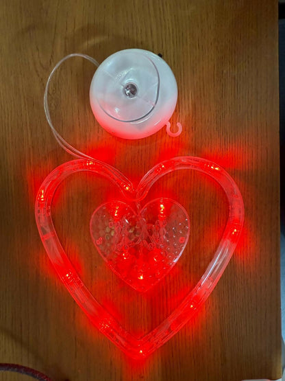 Heart shaped LED light hanging on balcony railing creating warm ambience