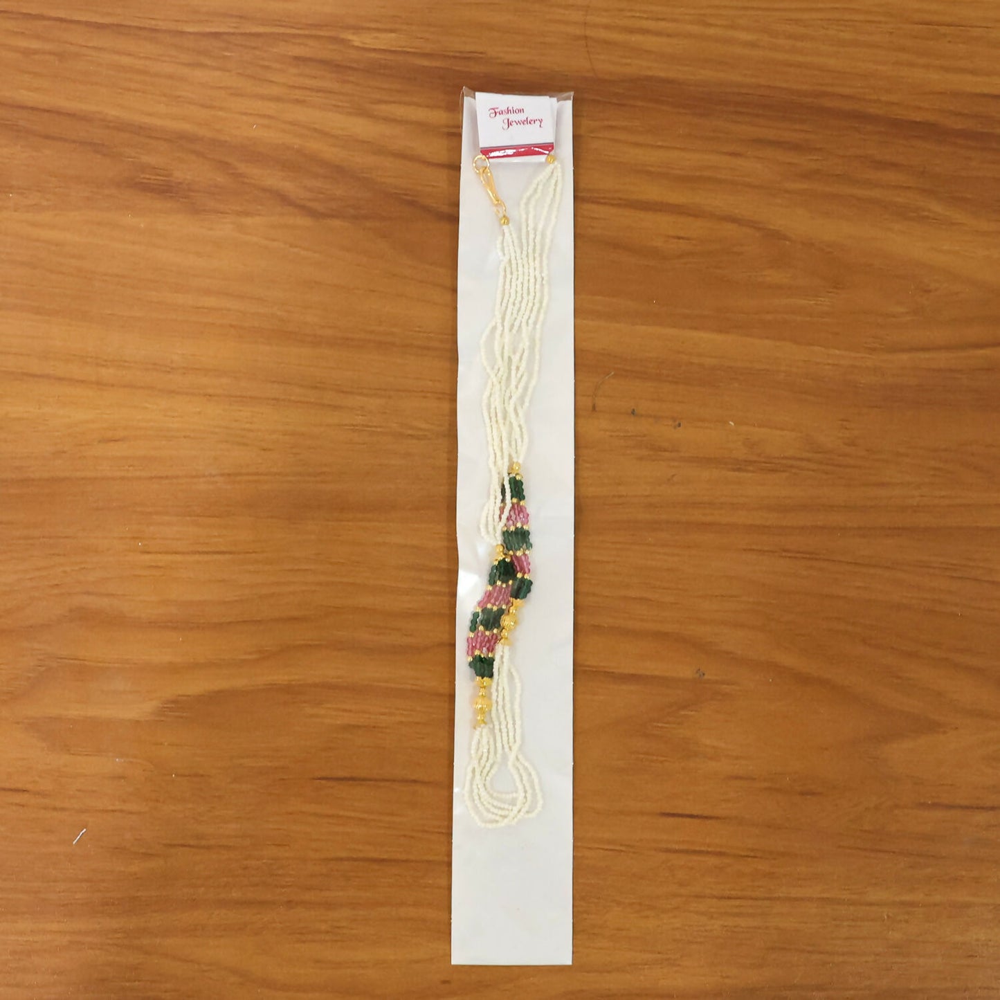 Handcrafted white mala necklace with colorful bead details on display