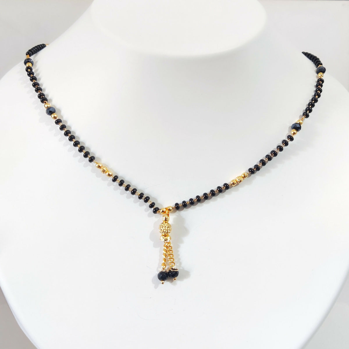 Model wearing black beaded mangalsutra with traditional outfit