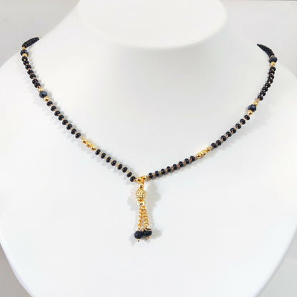 Model wearing black beaded mangalsutra with traditional outfit