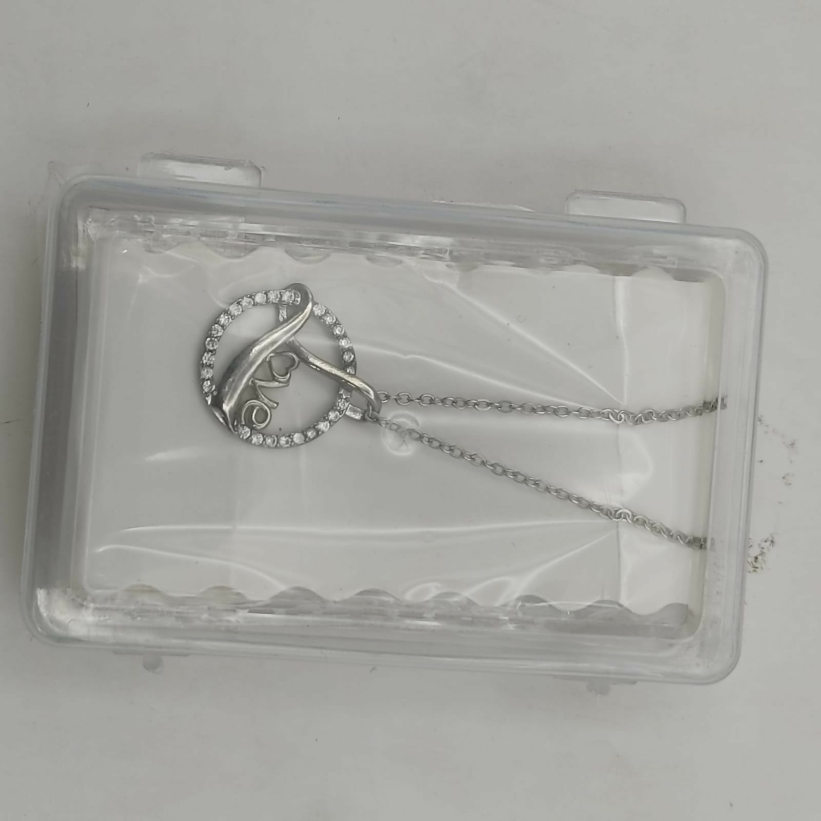 Model wearing the love script silver plated circle pendant necklace with adjustable chain