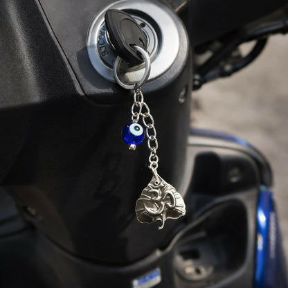 Om leaf evil eye keychain attached to a black bag