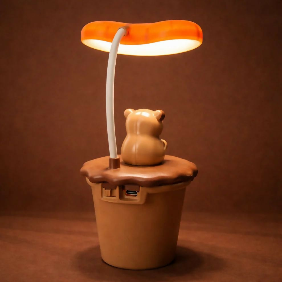 The back of a brown koala desk lamp reveals USB charging ports, set against a dark brown backdrop.