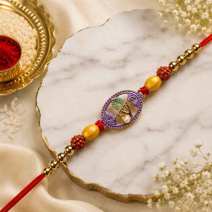 A red thread bracelet with a purple oval charm and beads lies on a white marble surface, with a gold bowl of rice and red