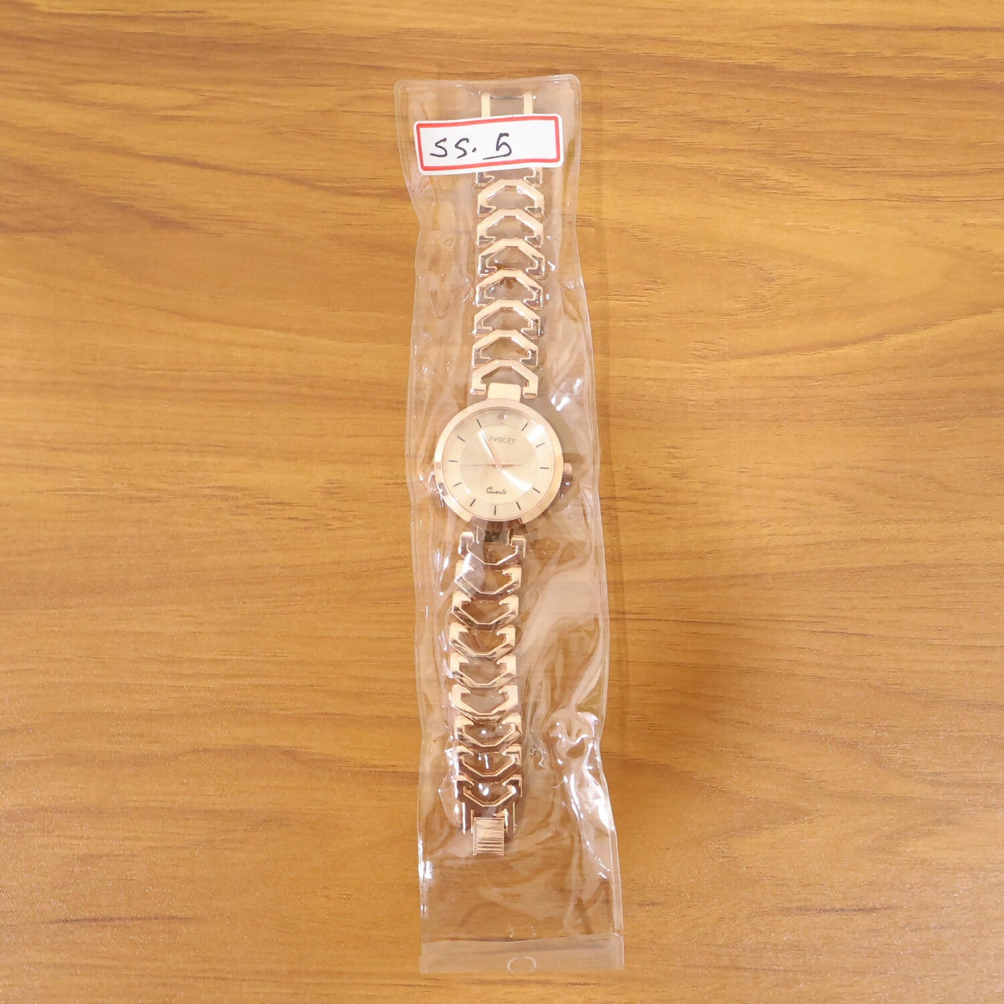 Rose gold analog wrist watch with bracelet strap on display