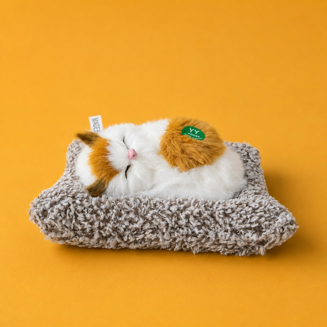 Sleeping cat plush toy displayed on office desk