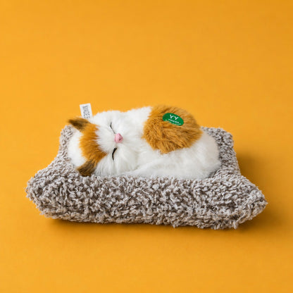 Sleeping cat plush toy displayed on office desk
