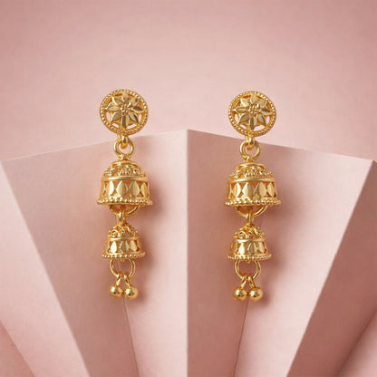 Pair of gold tone floral jhumka earrings on white background