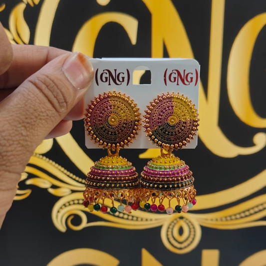 Front view of traditional gold jhumka earrings with multicolored detailing on white background