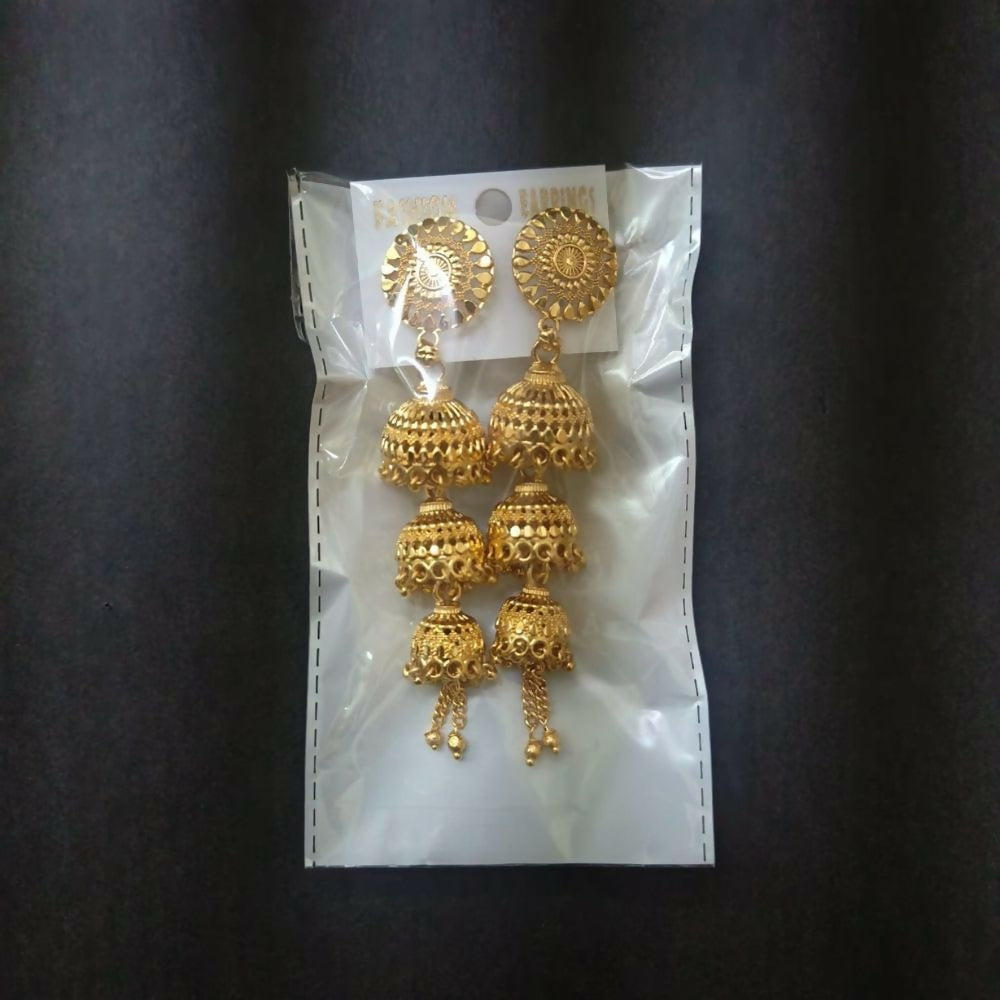 Woman wearing gold tone jhumki earrings, showcasing traditional style