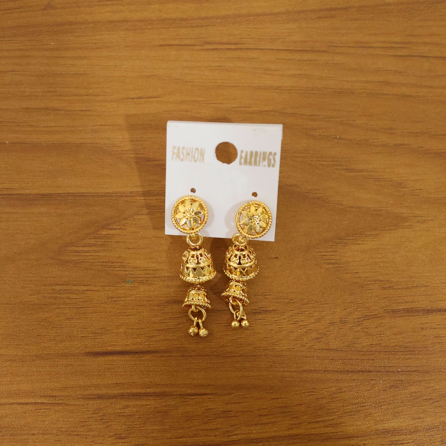 Front view of ethnic gold jhumka earrings with floral design