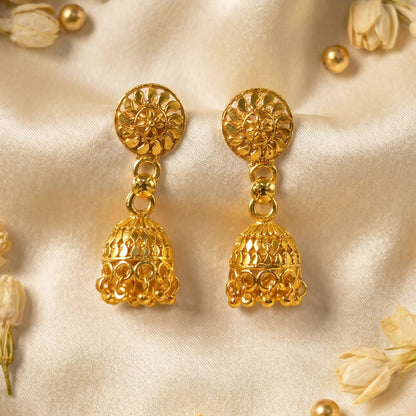 Pair of traditional gold jhumka earrings on white background
