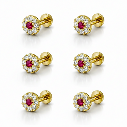 Set of three pairs of gold ruby halo stud earrings displayed elegantly on neutral background