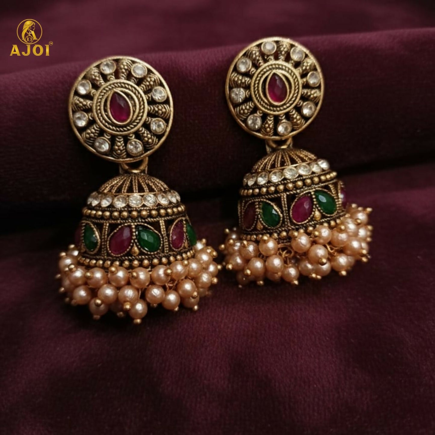 Royal Pearl Drop jhumka earrings against traditional fabric background
