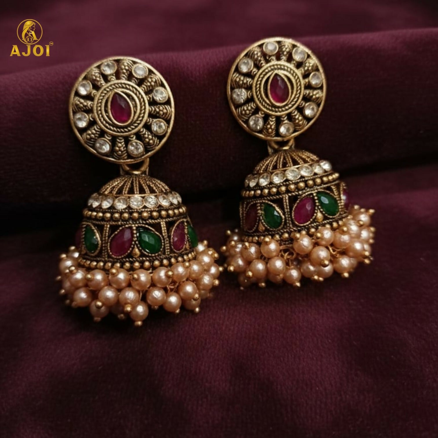 Royal Pearl Drop jhumka earrings against traditional fabric background