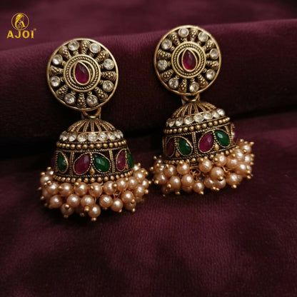 Royal Pearl Drop jhumka earrings against traditional fabric background