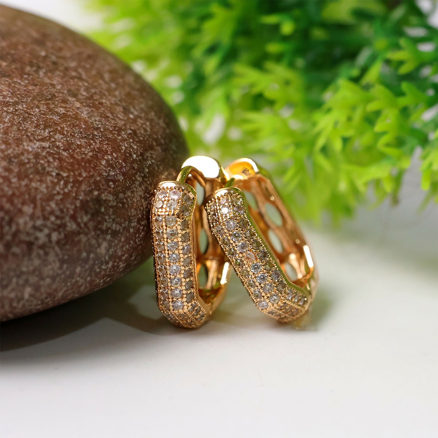 Gold finish CZ studded hoop earrings with oval cut design