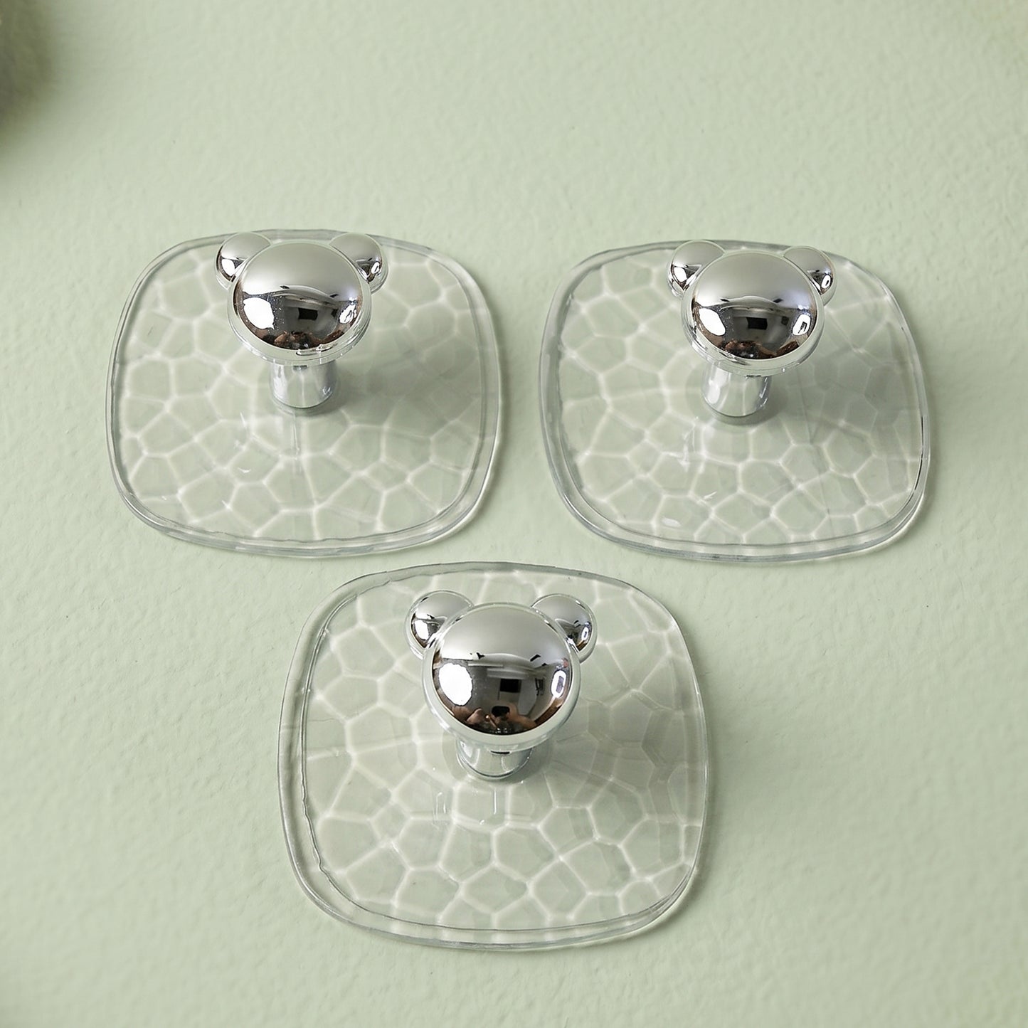 Clear adhesive wall hook holding a handbag in a hallway