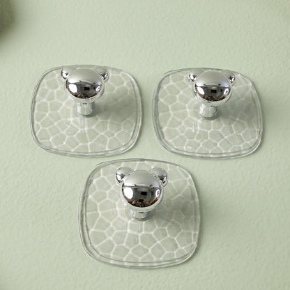 Clear adhesive wall hook holding a handbag in a hallway